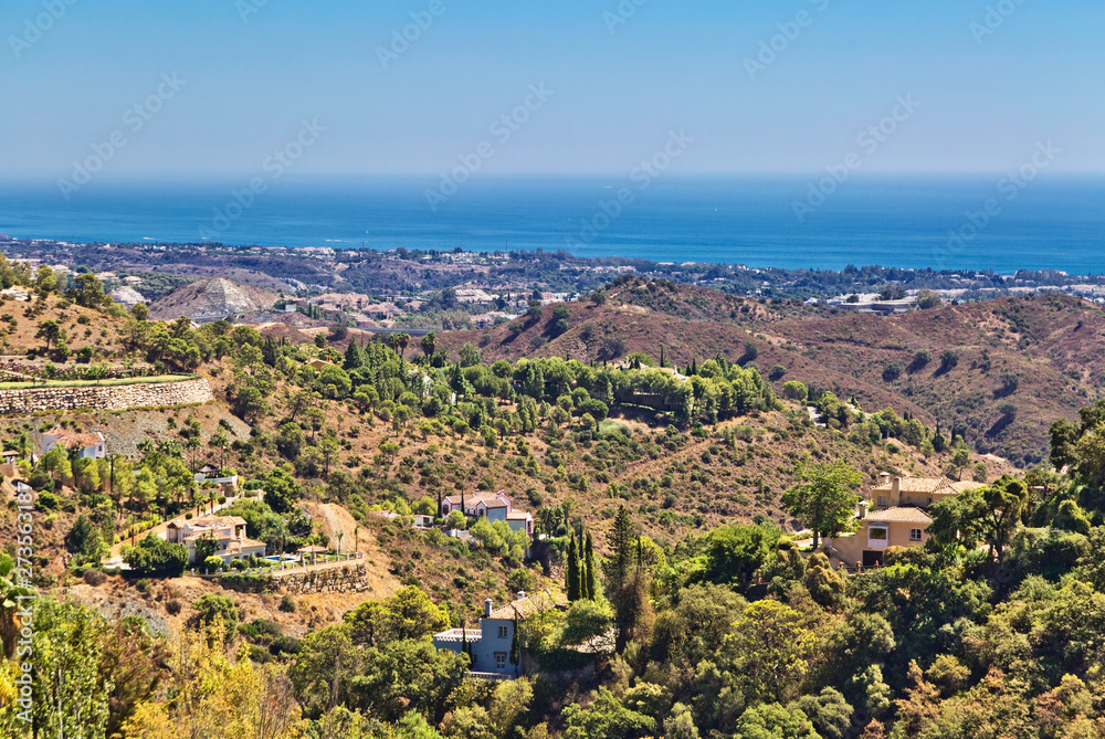 view of a beautiful hillside with the sea and mountains