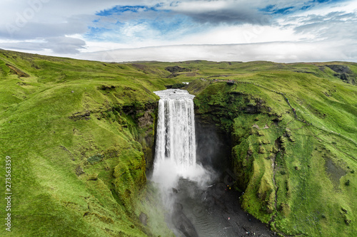 Iceland waterfall Skogafoss in Icelandic nature landscape. Famous tourist attractions and landmarks destination in Icelandic nature landscape on South Iceland. Aerial drone view of top waterfall. © Maridav