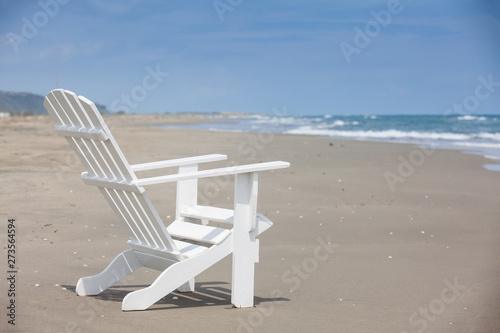 Empty white wooden chair at a paradisiac beach on the tropics in a beautiful sunny day © anamejia18