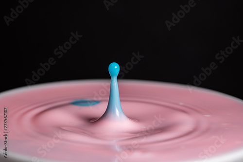 Splash of milk droplets in close up macro high resolution isolated against a black background