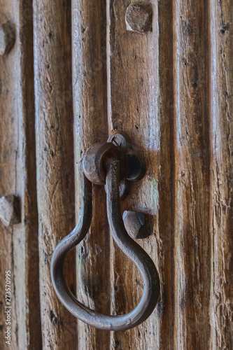 Old iron door knocker on a wooden door