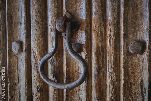 Old iron door knocker on a wooden door