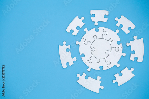 Unfinished white jigsaw puzzle pieces on blue background, The last piece of jigsaw puzzle, Copy space. photo