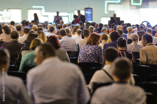 People attend a conference in a big hall.