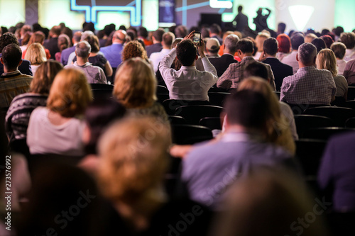 People attend a conference in a big hall.