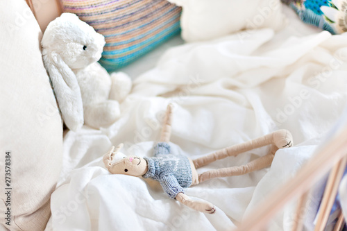 Fototapeta Naklejka Na Ścianę i Meble -  Hare toy dolls on the white sheet, bed with pillows