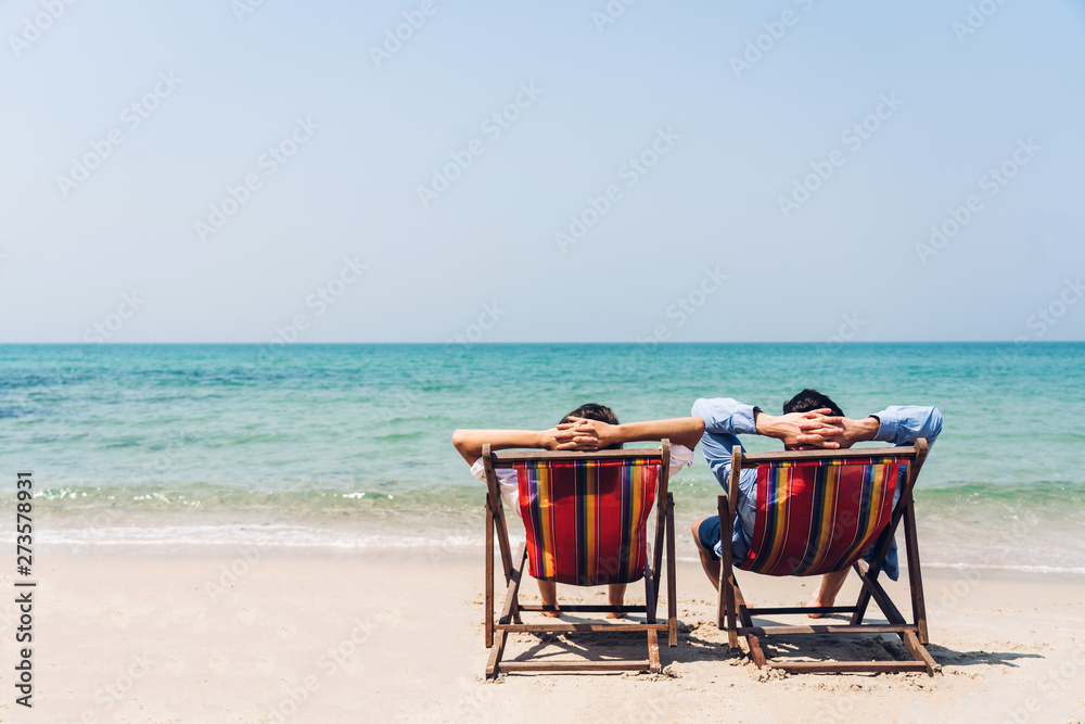 Romantic lovers young couple relaxing sitting together on the tropical beach and looking to the sea.Summer vacations Romantic lovers young couple relaxing sitting together on the tropical beach and looking to the sea.Summer vacations