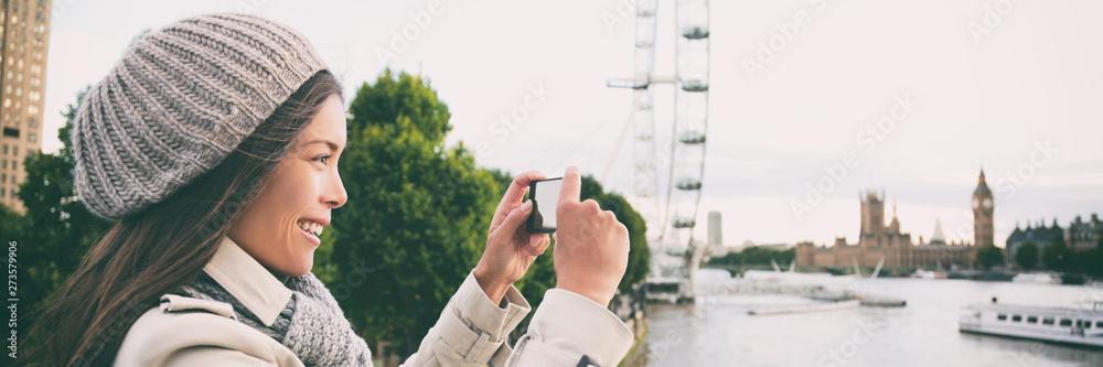 London europe travel woman taking pictures with phone panorama banner. Tourist holding smartphone camera taking photos at Big Ben, Westminster Bridge, London, England - obrazy, fototapety, plakaty 