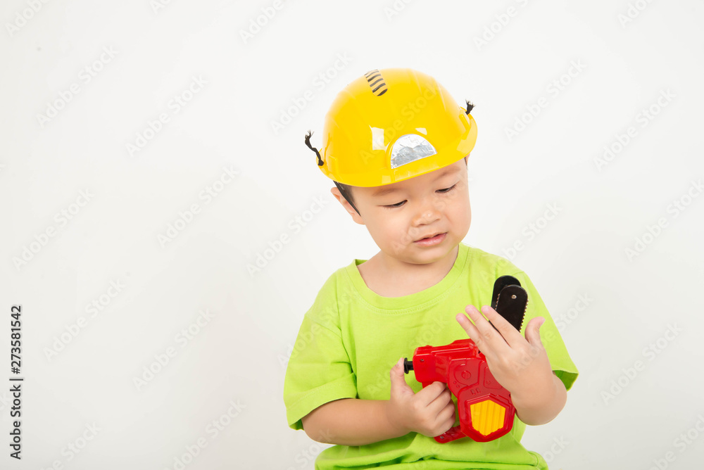 Little Asian toddler boy playing wood blocks wear helmet engineer Little Asian toddler boy playing wood blocks wear helmet engineer