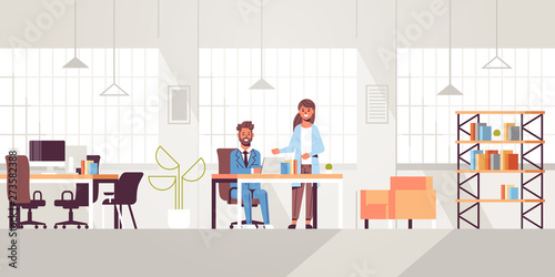 businessman with female assistant using laptop discussing new project during meeting at workplace teamwork concept creative workspace modern office interior flat full length horizontal