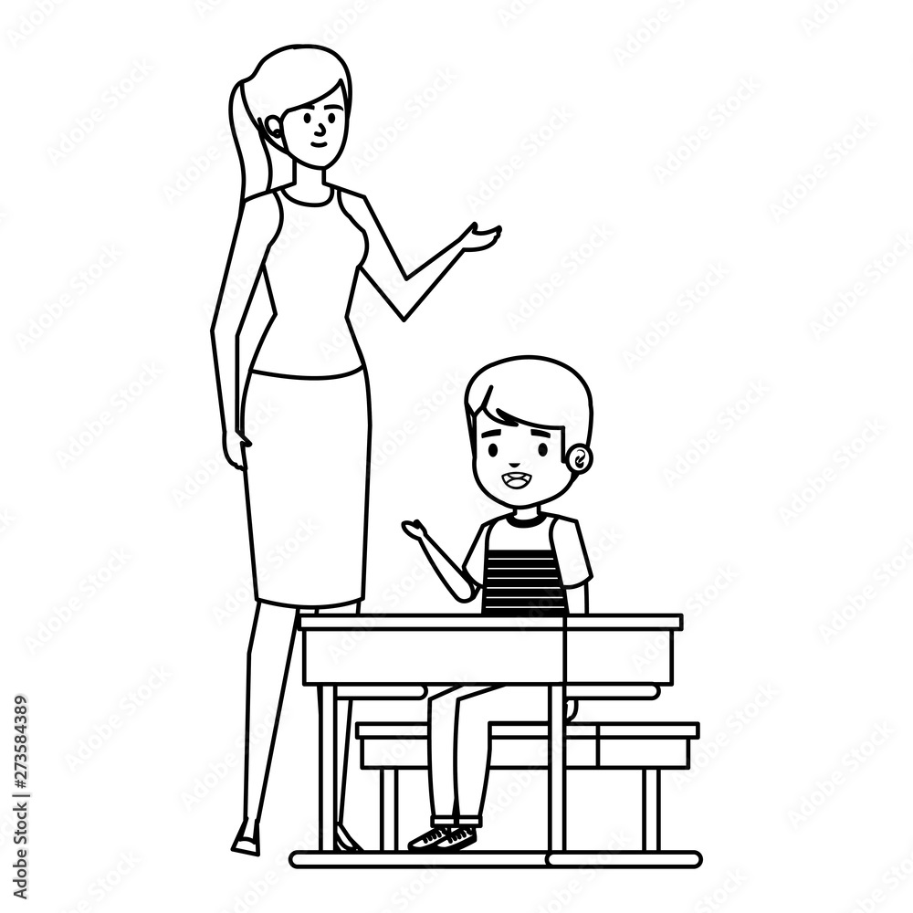 student boy seated in school desk with female teacher