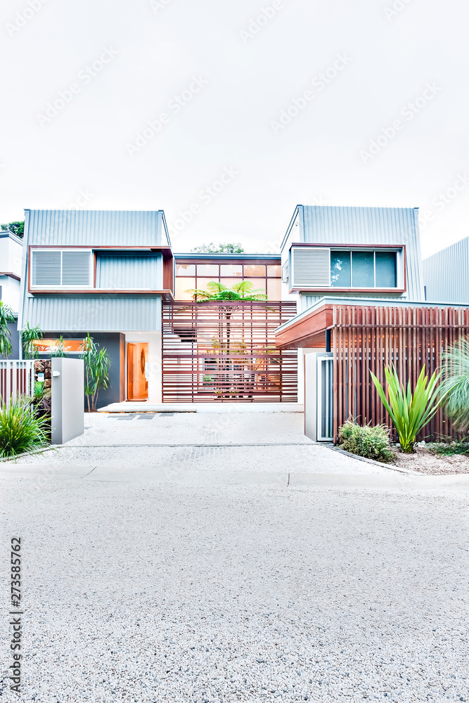 Modern house or hotel entrance road through the closed gate