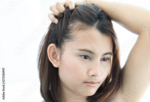 Woman looking reflection in the mirror serious hair loss problem for health care shampoo and beauty product concept