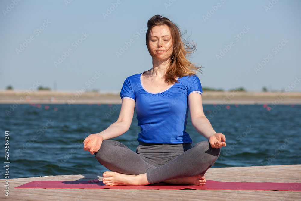 Beautiful young woman practicing yoga outdoors in morning Beautiful young woman practicing yoga outdoors in morning