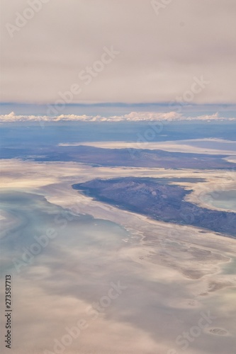Aerial view from airplane of the Great Salt Lake in Rocky Mountain Range, sweeping cloudscape and landscape during day time in Spring. In Utah, United States. © Jeremy
