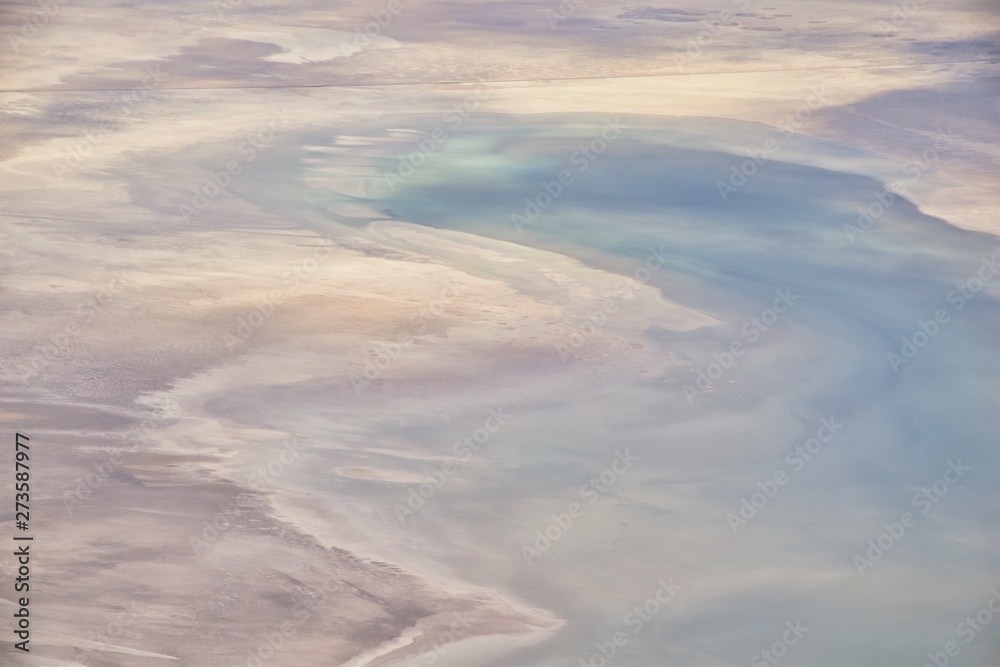 Aerial view from airplane of the Great Salt Lake in Rocky Mountain Range, sweeping cloudscape and landscape during day time in Spring. In Utah, United States.