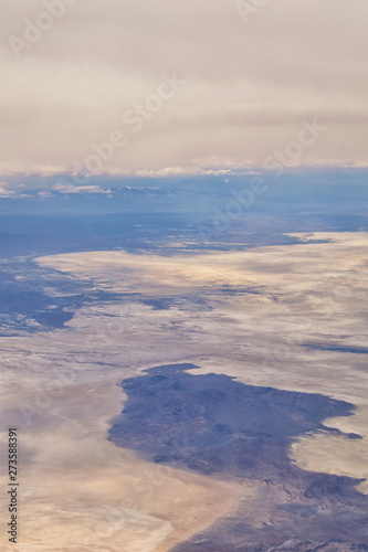 Aerial view from airplane of the Great Salt Lake in Rocky Mountain Range  sweeping cloudscape and landscape during day time in Spring. In Utah  United States.