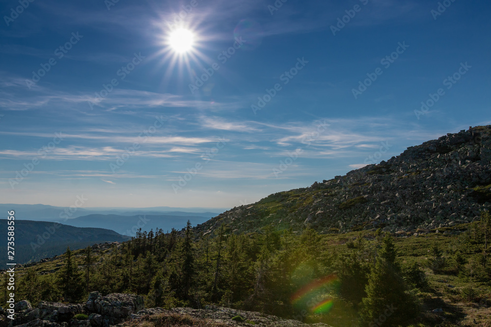 sun on a blue sky in the mountains in summer