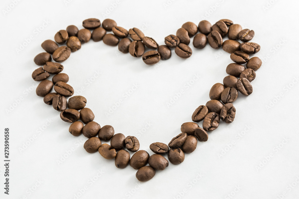 Coffee beans in the shape of a heart on a white background. Concept of freshness or great aroma and energy. Concept of Valentine's day. Coffee beans in the shape of a heart on a white background. Concept of freshness or great aroma and energy. Concept of Valentine's day.