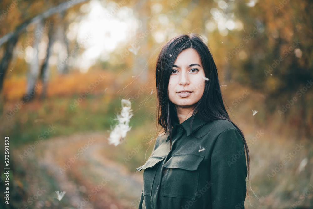 Dreamy beautiful girl in airy white fluff on bokeh background with yellow leaves. Inspired girl in autumn forest with golden foliage. Female beauty portrait among flying spores of thistle. Dreamy beautiful girl in airy white fluff on bokeh background with yellow leaves. Inspired girl in autumn forest with golden foliage. Female beauty portrait among flying spores of thistle.