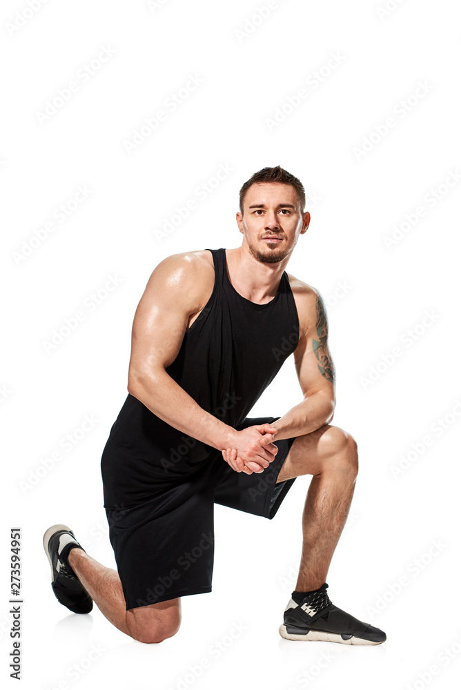 Fit strong muscular tattooed man posing on white background