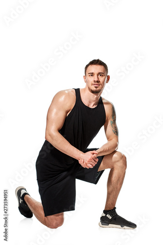 Fit strong muscular tattooed man posing on white background