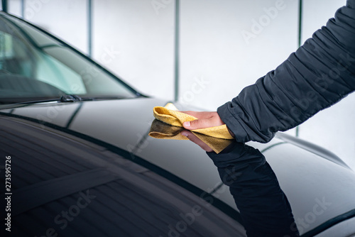 A person polishes the bonnet on his car