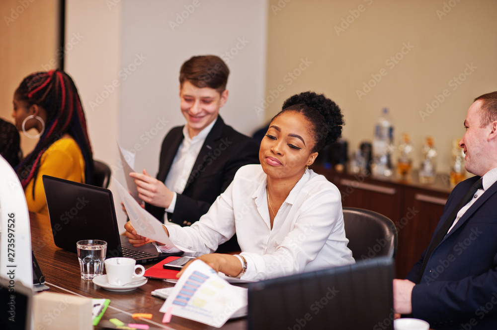 Multiracial business team addressing meeting around boardroom table. Multiracial business team addressing meeting around boardroom table.