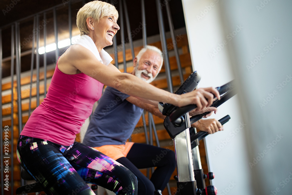 Happy senior people doing exercises in gym to stay fit