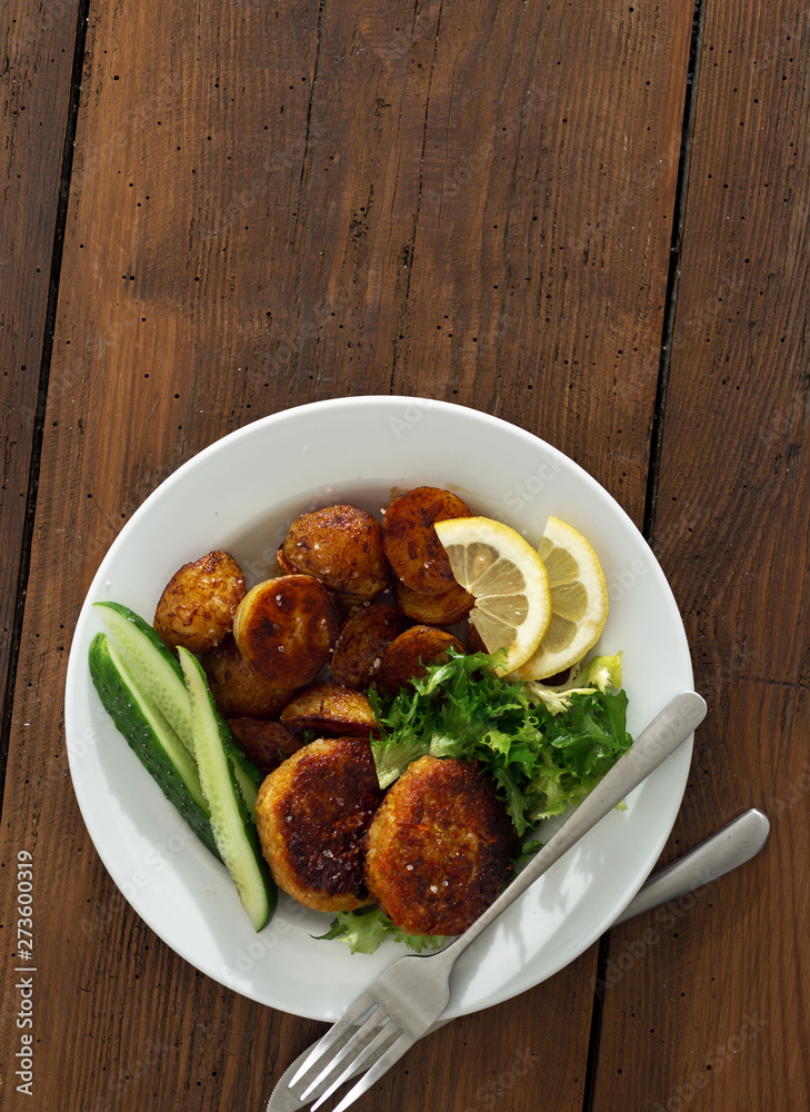 Plate of food. Fresh vegetarian cutlets with new potatoes and salad on a wooden table copy space top view Plate of food. Fresh vegetarian cutlets with new potatoes and salad on a wooden table copy space top view