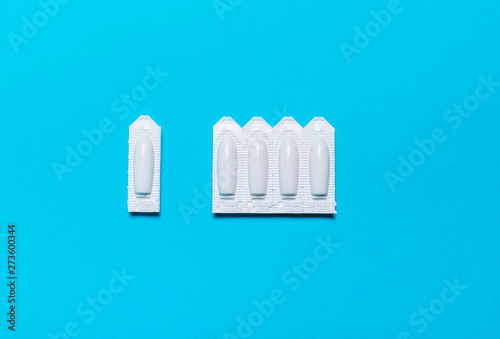 Suppository for rectal,vaginal use on blue background photo