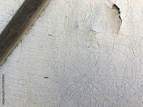 the outer wall of an old rural building, with a lot of cracks on the wallpaper