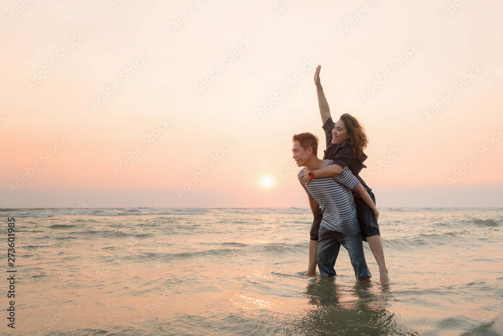 Fototapeta premium Happy asian couple having fun on the beach at sunset.