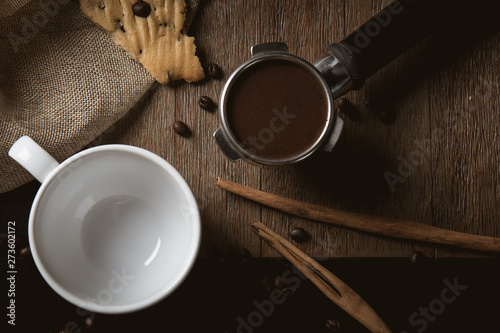 Empty cup of coffee decoration with coffee bean low light mood and tone on wooden table background