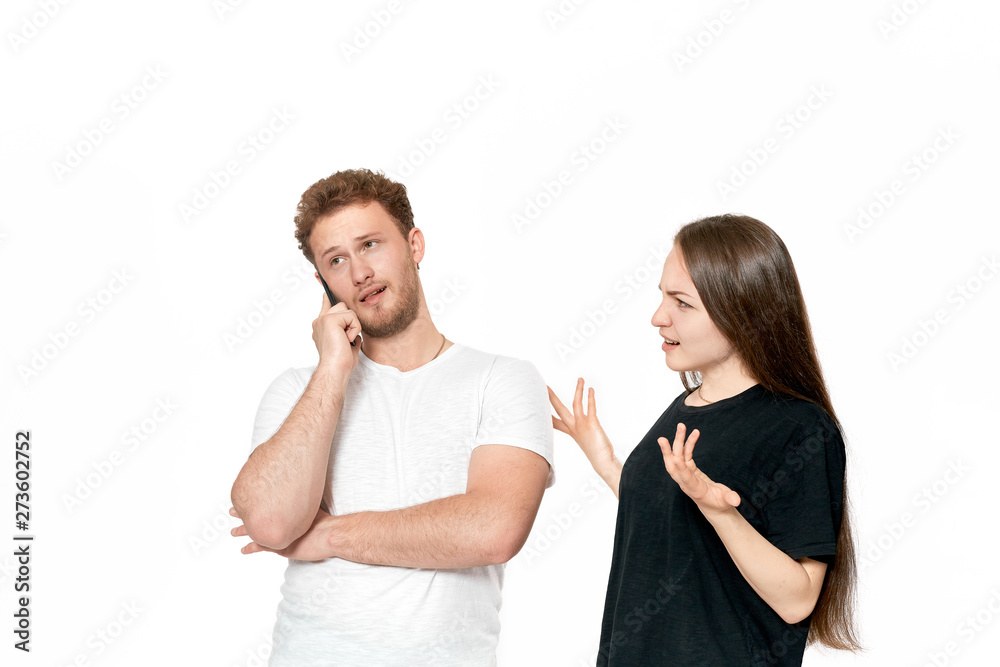 Studio shot of a couple quarreling. Dissatisfied woman looks with suspicion at the partner Studio shot of a couple quarreling. Dissatisfied woman looks with suspicion at the partner