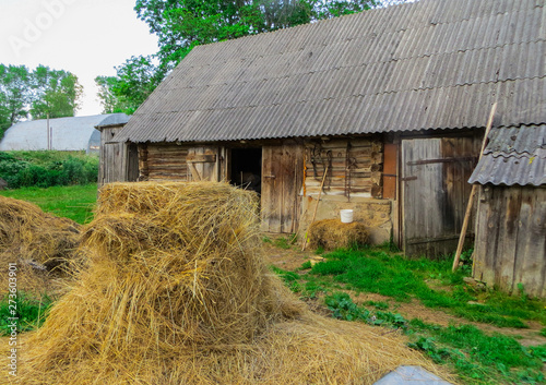 Old traditional abandoned buildings in the village.Country life.Stack of straw.