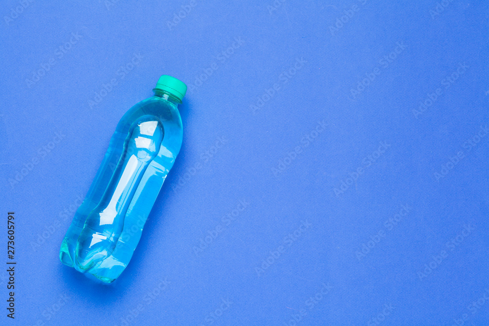 Naklejka premium Blank water bottle on blue background top view