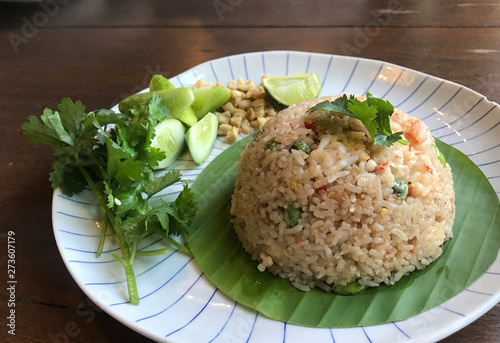 Spicy Chili paste fried rice with fresh shrimp and smelly bean Thai style serving with fresh vegetable on Banaba leaves