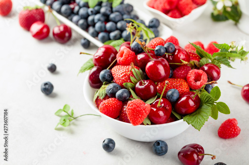 Berries closeup colorful assorted mix of strawberry  blueberry  raspberry and sweet cherry on a white table.