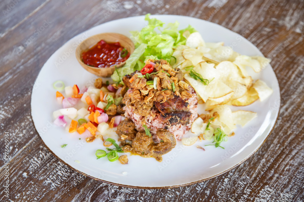 Rice and beef meat served with chips and green salad, casual dining restaurant food
