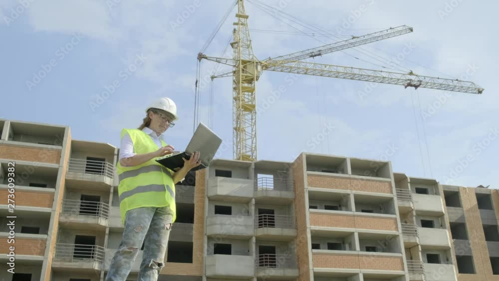 Woman foreman working on laptop at construction site of building. erection of multifamily residential area. Woman foreman working on laptop at construction site of building. erection of multifamily residential area.