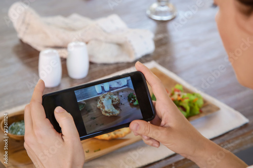 Woman taking a photo of her meal with a phone camera