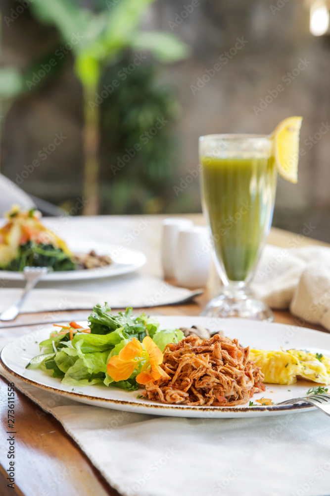 Healthy organic vegetarian dishes and glasses of detox drinks served on the restaurant table.	