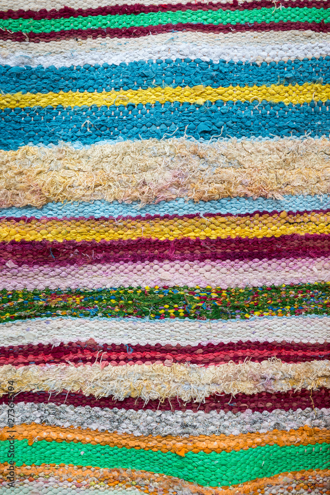 Colorful textile abstract background in a full frame close-up of imperfect woven layers