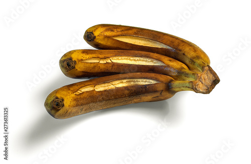 Rotten banana from the fridge, spoiled fruits. Isolated on white background. Darkened banan. Drops of condensation on the peel. Cracked skin.