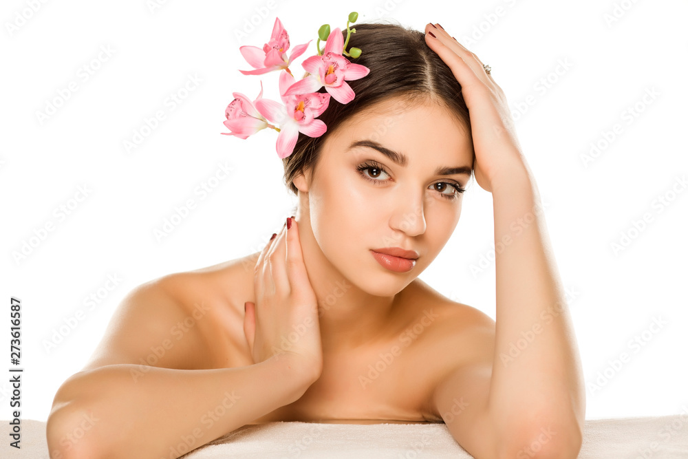 Young woman with makeup posing with orchids on white background Young woman with makeup posing with orchids on white background
