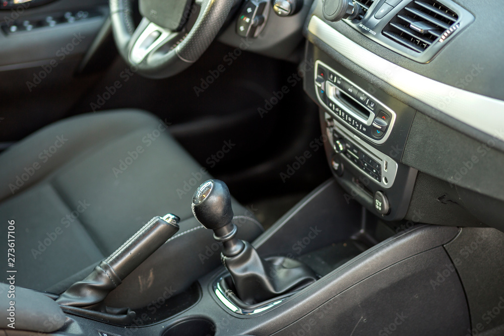 Luxurious car black leather interior. Handbrake manual brake and gearshift stick on blurred background. Transportation, design, modern technology concept.