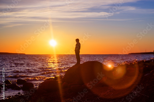 Silhouette of a man watching the sunset. Blurred image.