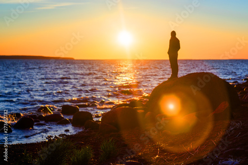 Silhouette of a man watching the sunset. Soft focus.
