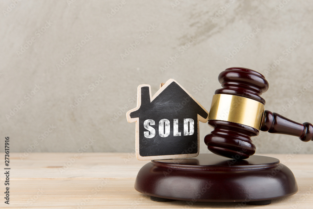 Real estate concept auction gavel and little house with inscription Sold